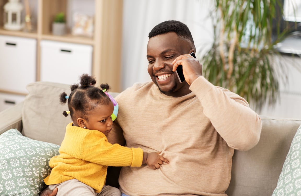 Father Taking Care of His Baby while Making a Call  